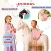 Two young girls interacting with a large toy horse, with inset images showing details of the toy. Anteprima dell’immagine prodotto