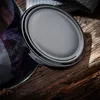 A close-up shot of a black jar lid resting on a rustic wooden surface, with plums visible in the background. Podgląd zdjęcia produktu