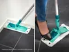 A collage of two images showing a mop being used to clean a floor, one in a corner and the other with a person's foot pressing down on it. Produktbild-Vorschau