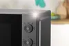 A close-up shot of the control panel and door handle of a gray microwave oven. Anteprima dell’immagine prodotto