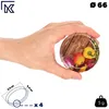 A hand holding a metal lid with a vegetable print. Voir les images du produit
