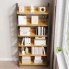 A tall, narrow bookshelf filled with books and decorative items, placed next to a window with a view of greenery. Produktbild-Vorschau