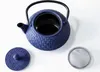 A blue cast iron teapot with its lid and a tea strainer are displayed on a white background. Podgląd zdjęcia produktu