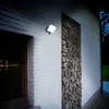 A white brick wall with a recessed section filled with firewood, illuminated by a white LED floodlight. Produktbild-Vorschau
