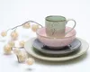 A stack of ceramic dishes and a mug, with a decorative sprig of dried flowers to the left. Náhľad obrázku produktu