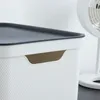Close-up of a white storage box with a dark gray lid and a brown interior handle. Produktbild-Vorschau