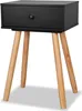 A black bedside table with wooden legs against a white background. Náhľad obrázku produktu