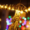 A close-up of string lights wrapped around a branch, with blurred colorful bokeh lights in the background. Produktbild-Vorschau