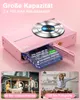 A pink digital camera with its battery compartment open, showing the battery. Below are two smaller images, one showing a family playing outside and the other showing a person posing. Produktbild-Vorschau