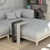A modern living room scene with a sectional sofa and a C-shaped side table. Produktbild-Vorschau