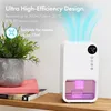 A white dehumidifier with a pink water tank is shown on a wooden shelf next to a potted plant and books. Blue air currents are depicted flowing from the top of the dehumidifier. Produktbild-Vorschau