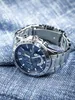A silver Casio Edifice watch with a blue face rests on a textured blue fabric. Podgląd zdjęcia produktu