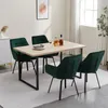 A dining set with four green velvet chairs around a light wood table in a well-lit room. Voir les images du produit