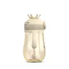 A baby bottle with a crown-shaped lid and a straw. Produktbild-Vorschau