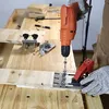 A person is using a drill and a jig to create a hole in a piece of wood. Náhľad obrázku produktu