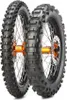 Two dirt bike tires are shown side-by-side against a white background. One tire is slightly in front of the other, obscuring part of the rear tire's hub and brake disc. The front tire's tread pattern is clearly visible, with large, blocky knobs designed fo Produktbild-Vorschau