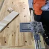 A person is using a drill with a jig to drill holes in a piece of wood. Náhľad obrázku produktu