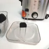 A close-up shot of a mini deep fryer and fondue pot accessory, with a portion of the main appliance visible in the background. Produktbild-Vorschau