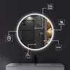 A round LED mirror is shown in a modern bathroom setting, with icons highlighting its features. Voir les images du produit