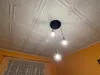 A pendant light fixture with three cage-style lamps hangs from a textured white ceiling. Náhled obrázku produktu