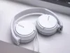 A pair of white Sony headphones resting on a white surface. Podgląd zdjęcia produktu