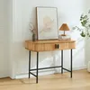 A console table with two doors and black legs, placed against a white wall with a framed picture and a lamp on top. Podgląd zdjęcia produktu