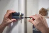 A person is using a tool to install or adjust a door hardware component. Produktbild-Vorschau