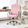 A pink velvet office chair with diamond tufting is shown in a well-lit room with a desk and shelves in the background. Produktbild-Vorschau