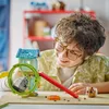 A young boy with glasses is playing with a LEGO set. Podgląd zdjęcia produktu