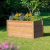 A wooden raised garden bed filled with yellow and purple flowers, set in a grassy garden. Produktbild-Vorschau