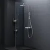 A modern shower fixture with a rain showerhead, handheld shower, and glass shelf, set against dark tiled walls. Podgląd zdjęcia produktu