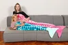 A woman and a child are lying on a couch, wrapped in mermaid tail blankets. Anteprima dell’immagine prodotto