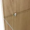 A close-up view of a shelf support bracket holding a glass shelf against a wooden cabinet. Produktbild-Vorschau