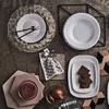 A flat lay of tableware and food items on a textured surface. Voir les images du produit