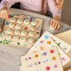 Children playing with a wooden memory game on a table. Anteprima dell’immagine prodotto