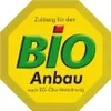 A yellow octagonal badge with green text that says "BIO Anbau" and smaller text above and below. Podgląd zdjęcia produktu