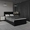A bedroom scene with a bed, nightstand, and curtains.