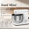A white stand mixer with a silver bowl is shown on a countertop, with text and icons detailing its features. Produktbild-Vorschau