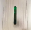 A close-up view of a green liquid in a transparent dispenser on a silver, ribbed surface. Podgląd zdjęcia produktu