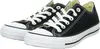 A pair of black Converse All Star low-top sneakers with white laces and soles, shown from a slightly elevated side angle against a white background. Voir les images du produit