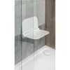 A white folding shower seat mounted on a tiled wall in a shower stall. Anteprima dell’immagine prodotto