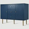 A navy blue sideboard with a decorative pattern and gold legs, shown against a light gray background. Náhled obrázku produktu