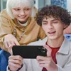 Two young people are looking at a smartphone held by one of them. Anteprima dell’immagine prodotto