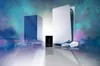A gaming console, a hard drive, and a controller are displayed on a reflective surface with a colorful, smoky background. Produktbild-Vorschau