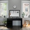 A black vanity table with drawers and a large mirror, set in a well-lit room with windows and decorative items. Náhled obrázku produktu