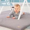 A baby is lying on a play mat under a play gym. Náhled obrázku produktu