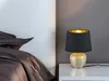 A bedside table with a lamp and bedding. Náhled obrázku produktu