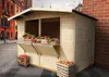 A wooden market stall filled with fruits and vegetables, set up on a cobblestone street in front of old buildings. Náhľad obrázku produktu