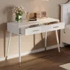 A white vanity table with two drawers and gold accents, set against a neutral wall. Podgląd zdjęcia produktu