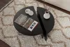 A split circular coffee table with a book and a vase on it, placed on a textured rug. Produktbild-Vorschau